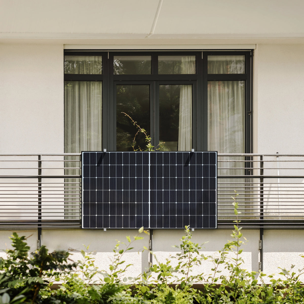Balkonkraftwerk am Balkon mit Balkontür und weißer Wand im Hintergrund